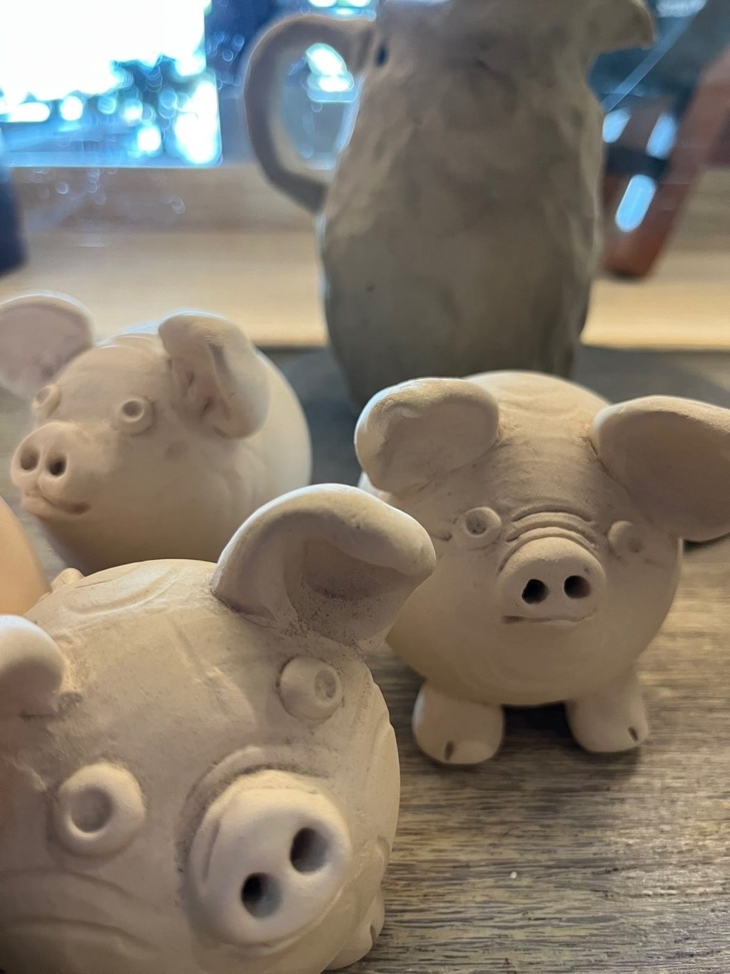 Petits cochons en argile modelés à la main, séchant avant la cuisson