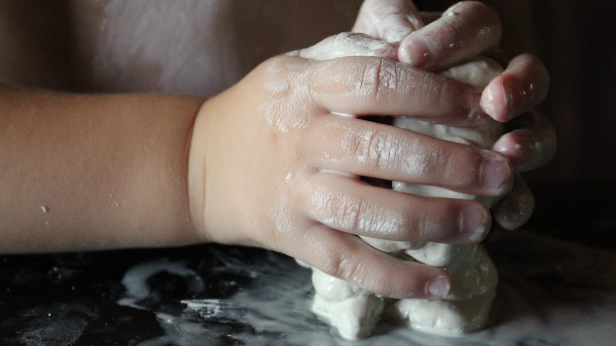 Mains d'enfant pétrissant de l'argile blanche autodurcissante