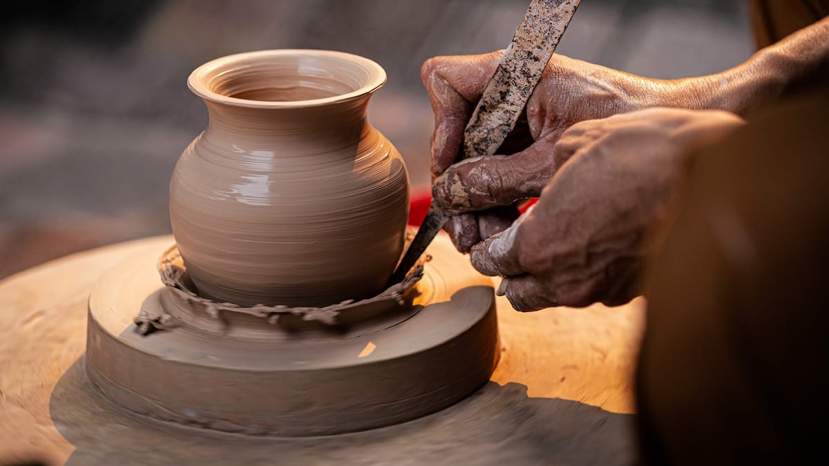 Mains d'un potier façonnant un vase en argile sur un tour